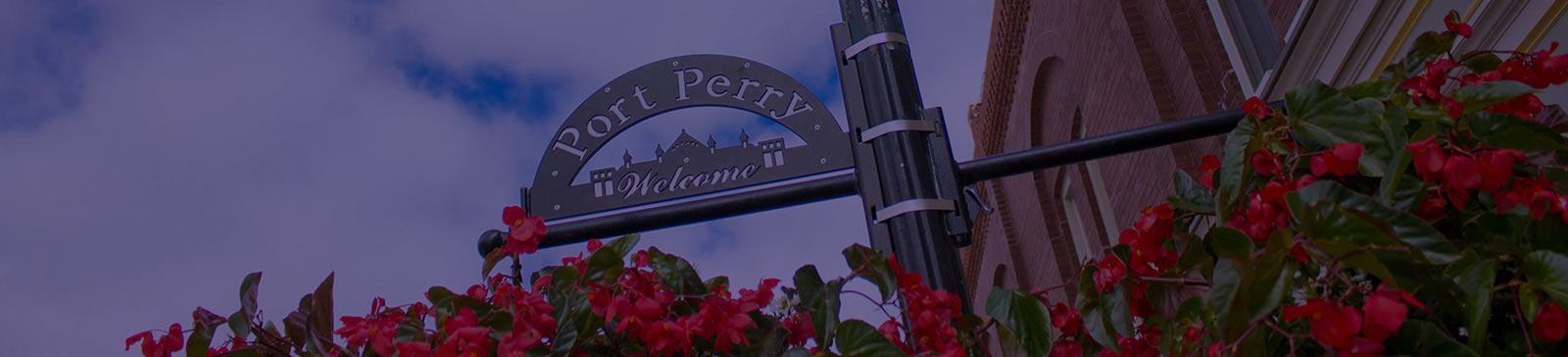 Port Perry welcome sign with hanging flower baskets.