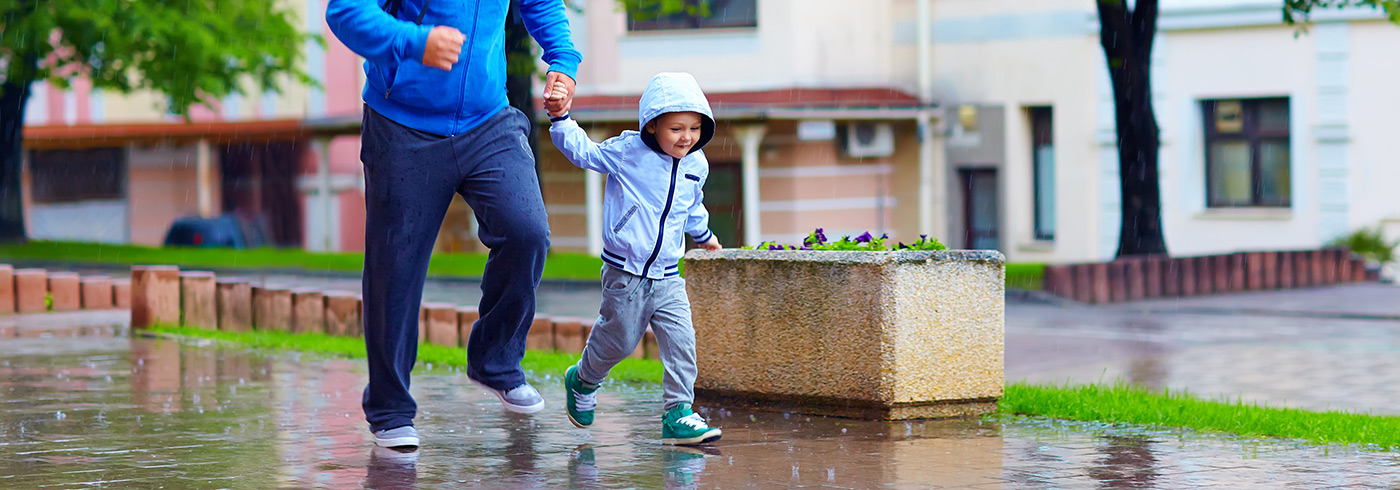 Parent and child walking in the rain.