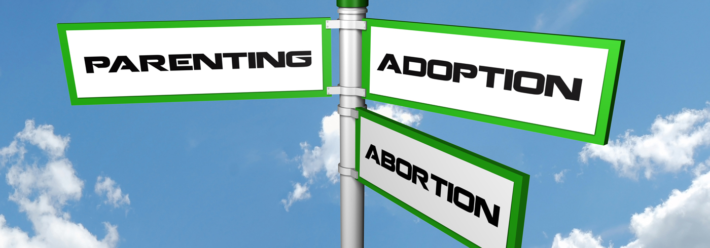 Three signs stating "parenting", "adoption" and "abortion".
