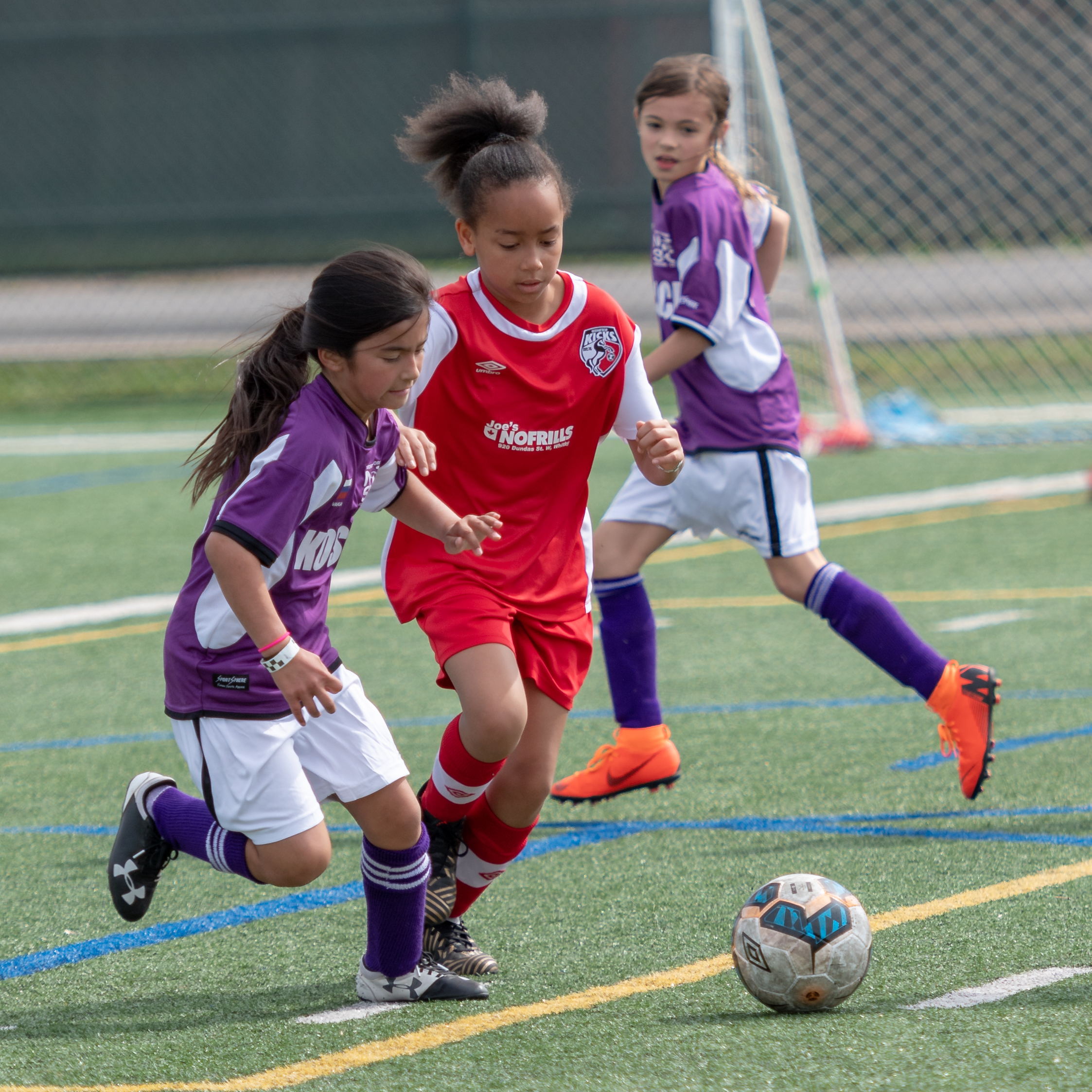 A picture of three children playing soccer