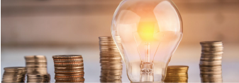 A picture of a lightbulb with coins in the background