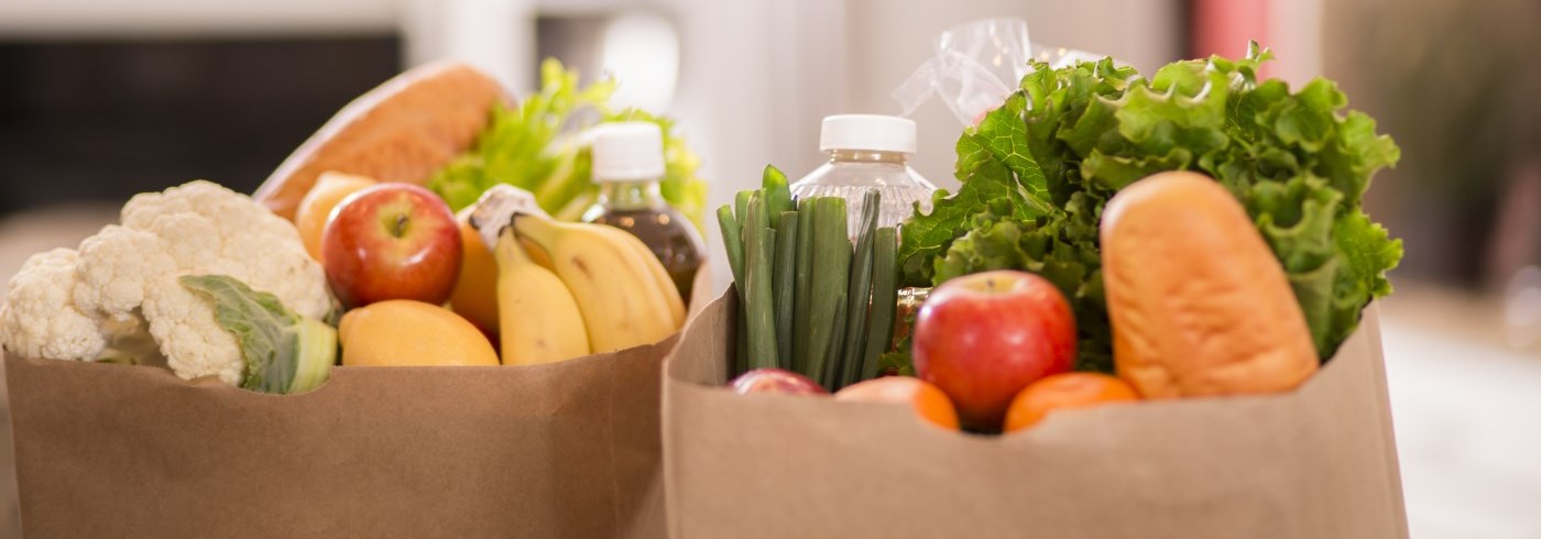 A picture of groceries (mostly fresh produce) in paper grocery bags