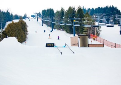 People skiing down hill under chair lift at Brimacombe