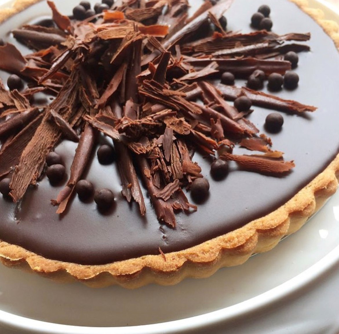 Chocolate tart with brown crust, chocolate ganache and shaved chocolate on top