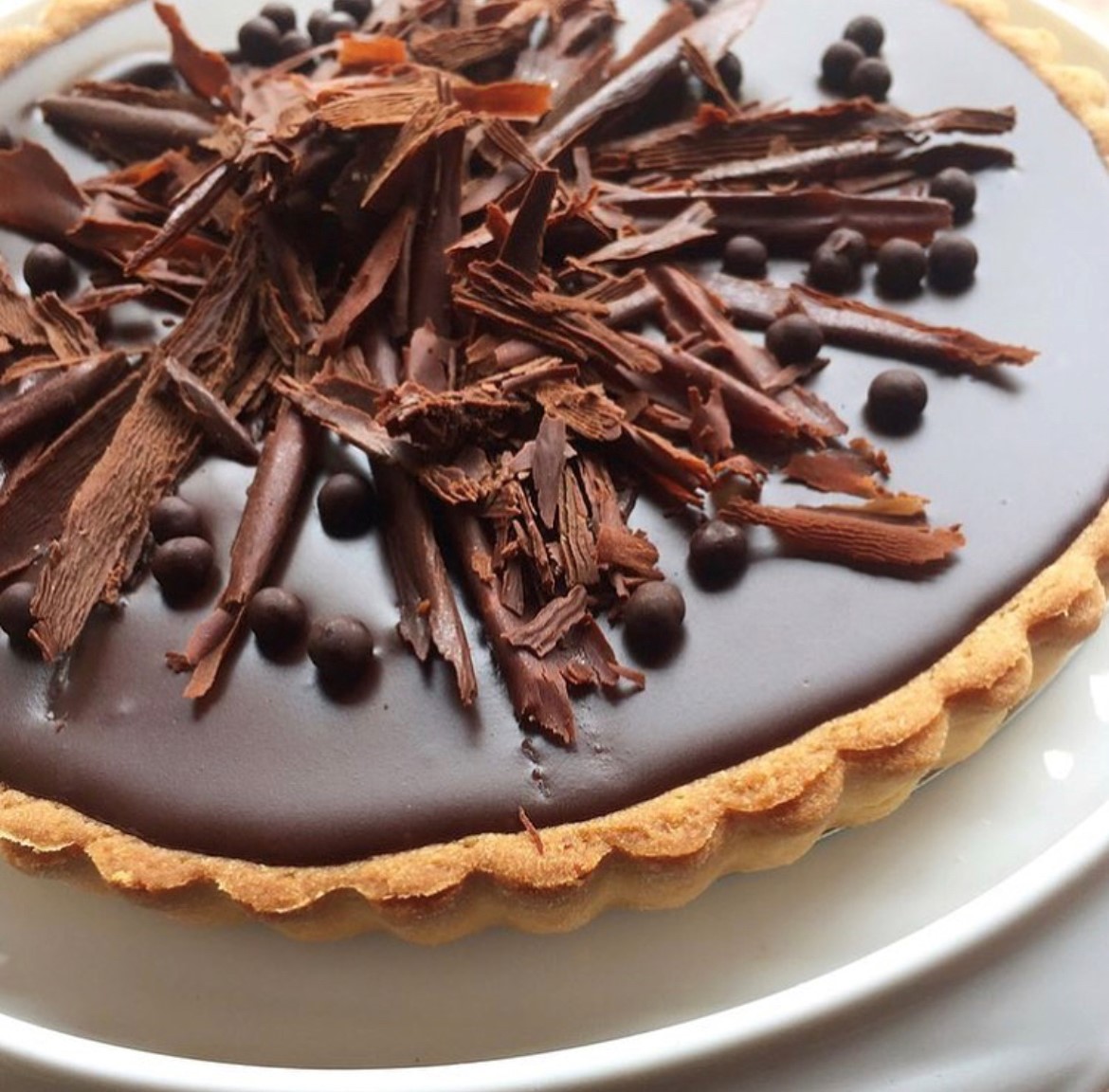 Chocolate tart with brown crust, chocolate ganache and shaved chocolate on top