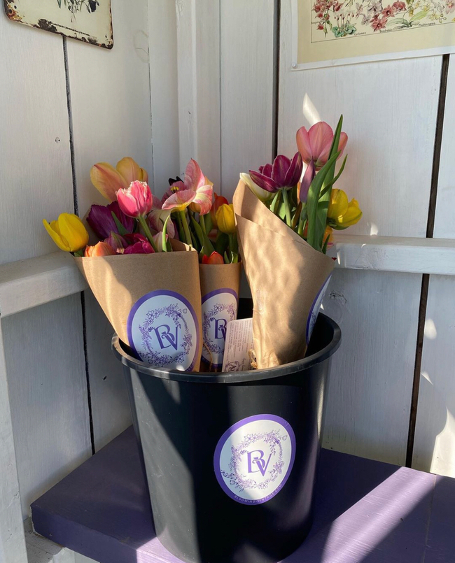 Black bucket of spring flowers bouquets wrapped in brown paper