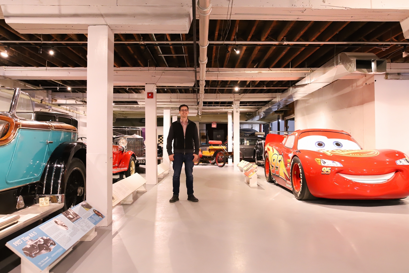 Man standing in front of replica Lightening McQueen car