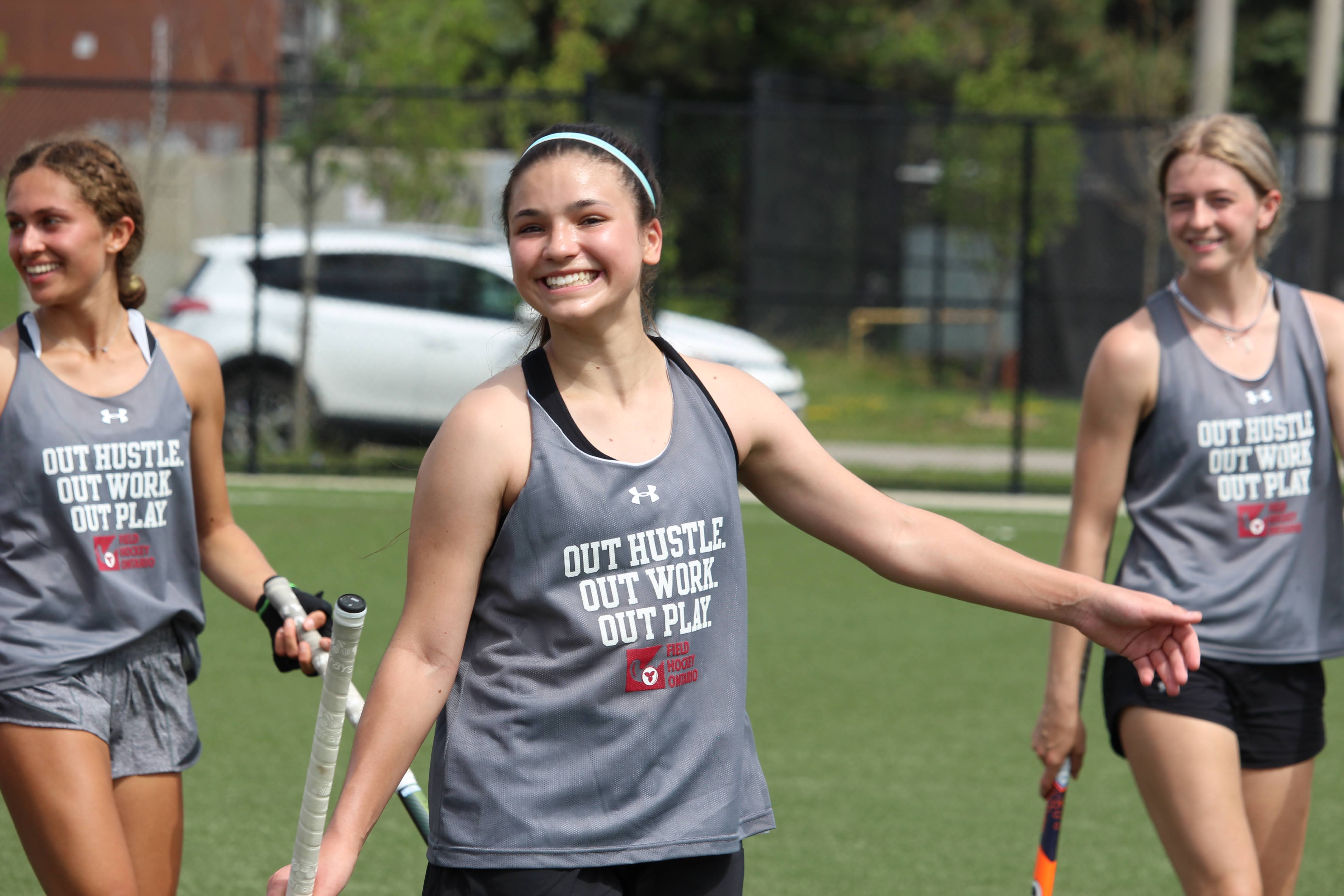 Field hockey players smiling on the field