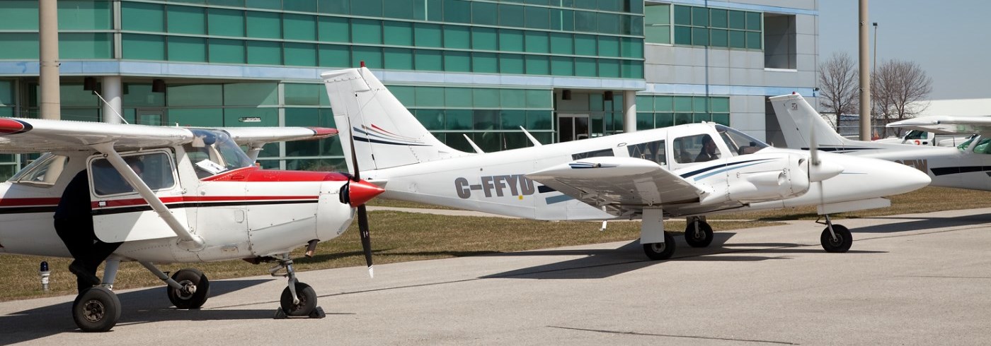 Exterior of Oshawa Executive Airport with three planes in front