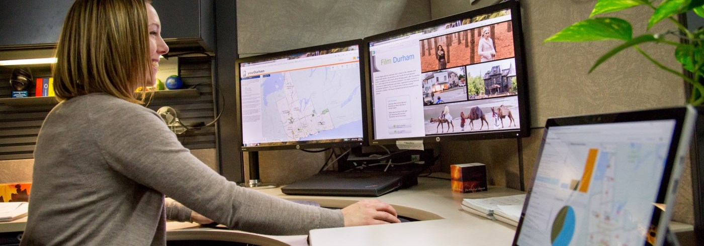 Woman sitting at a computer looking at maps