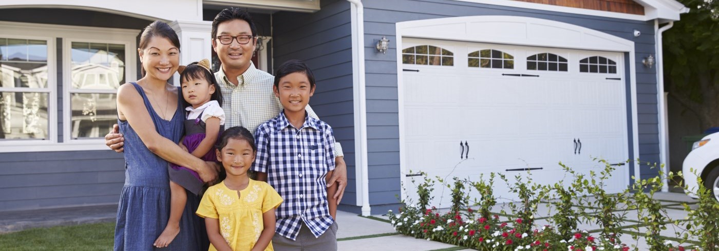 Family standing in front of house