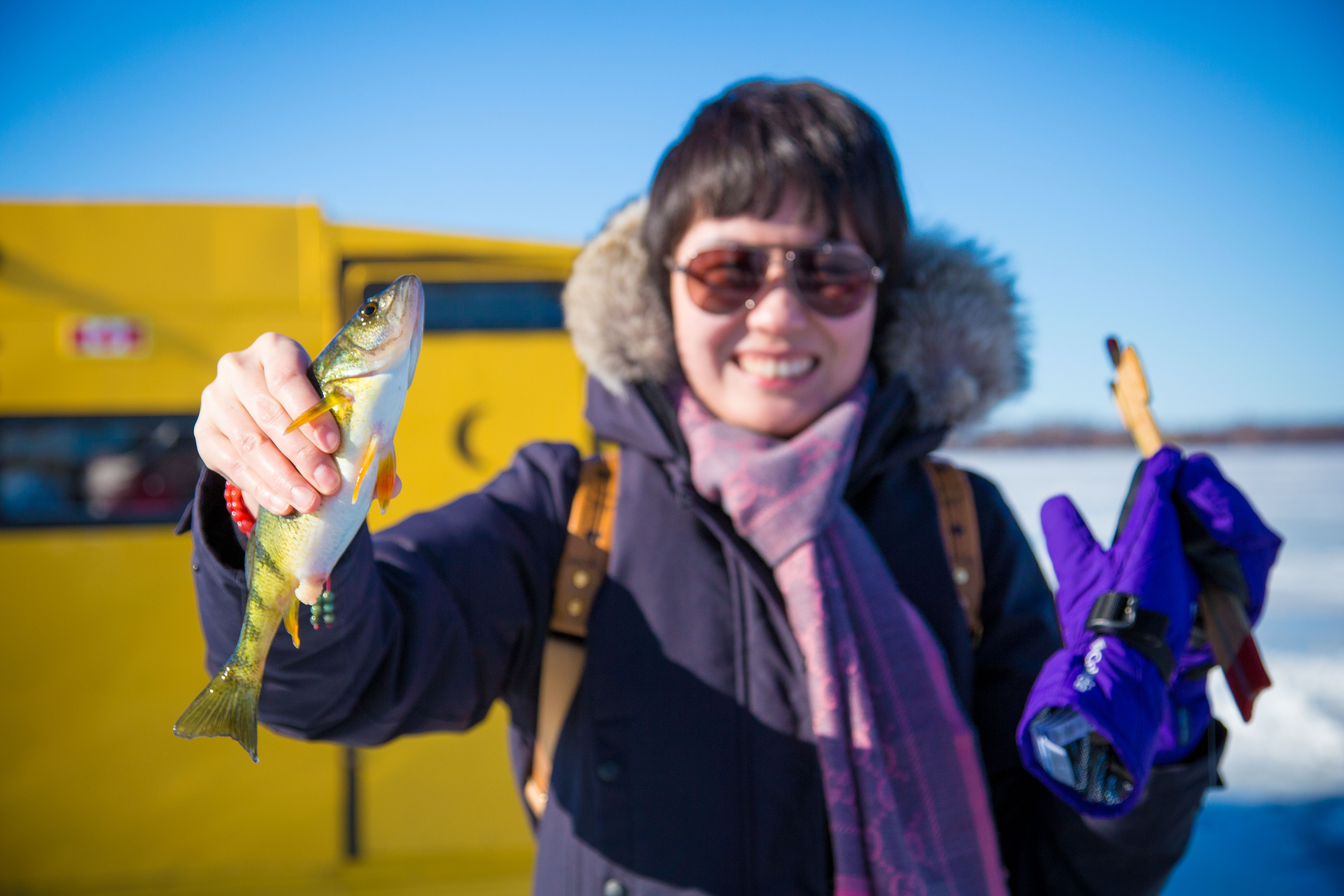 Woman holding fish after ice fishing on Lake Scugog