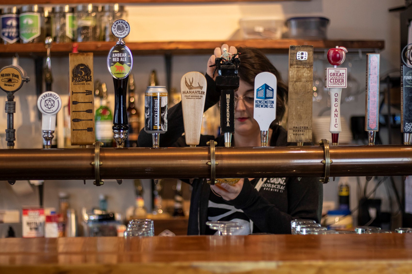 Bar showing beer spouts with a person pouring a beer