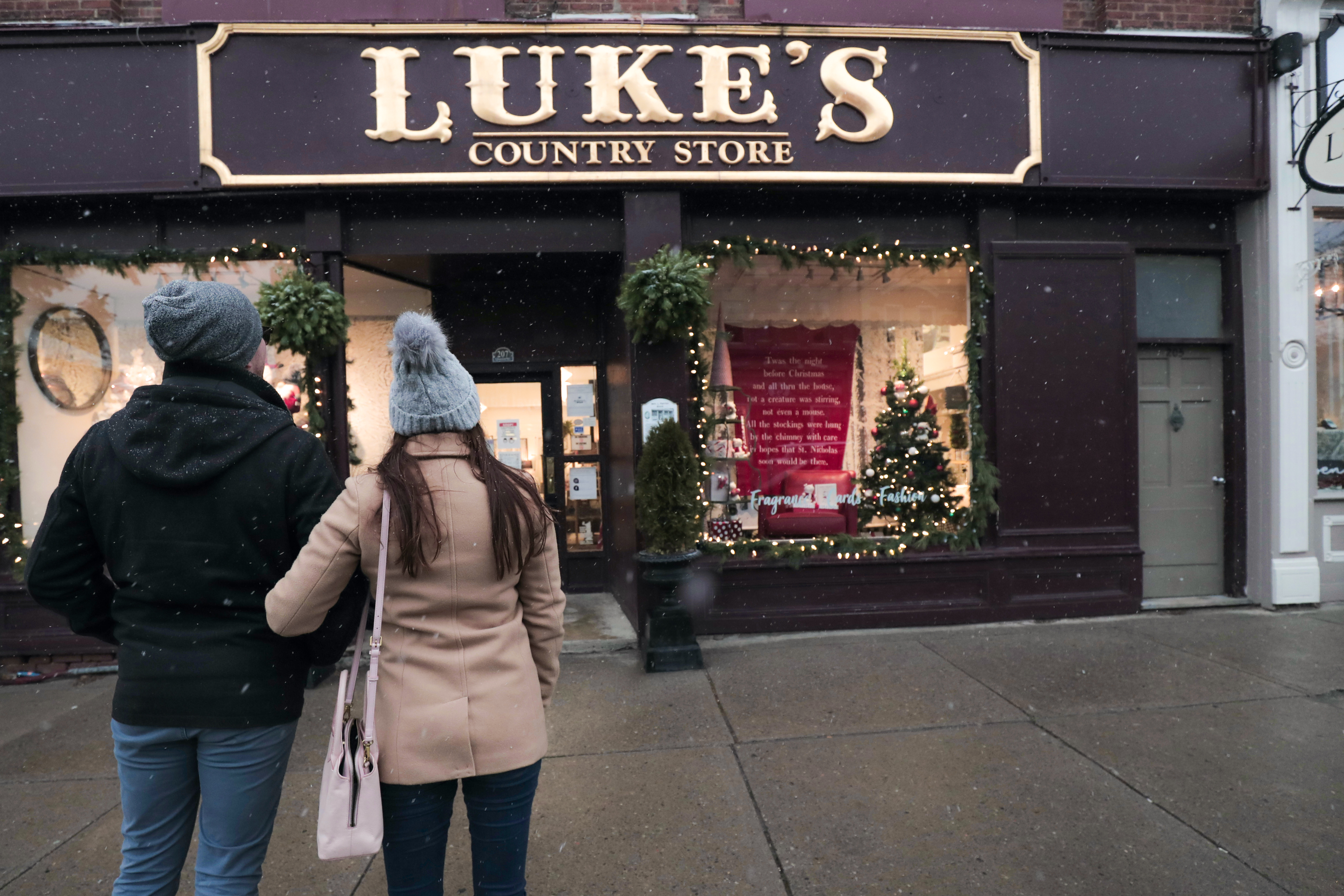 A couple standing infront of Luke's in Downtown Port Perry in winter.