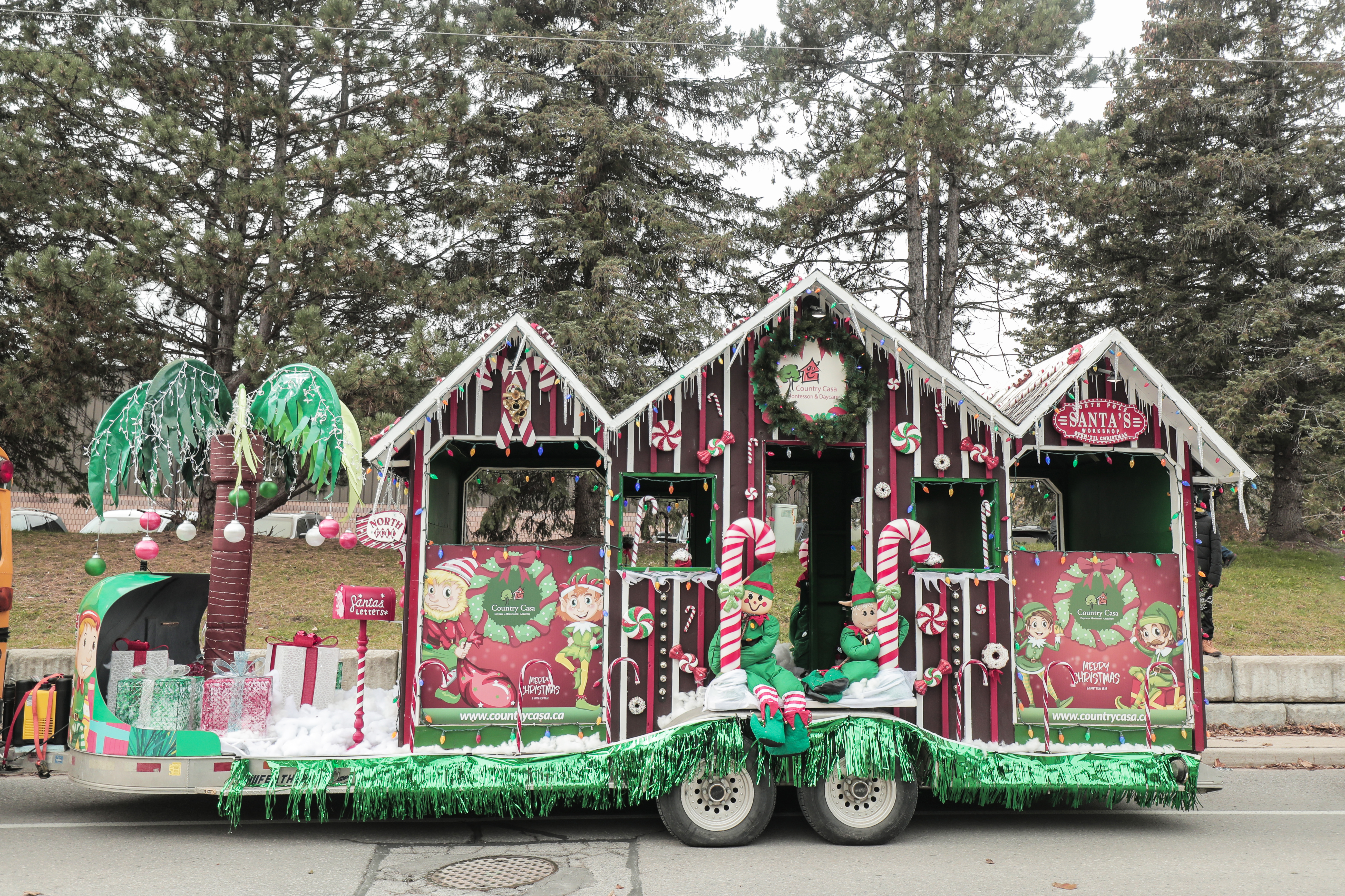parade float with houses, candy canes, elves with the colours of green, red and brown.