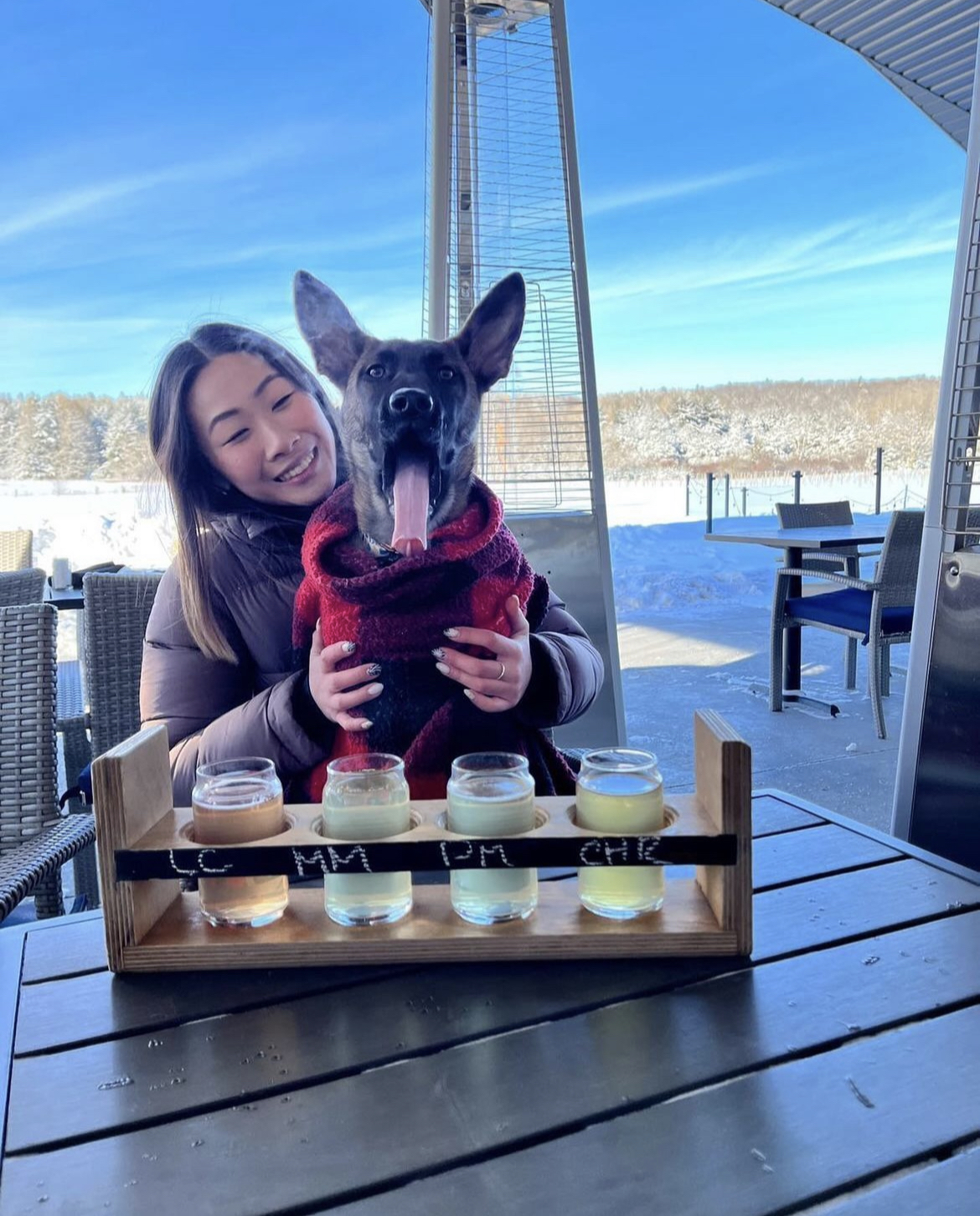 Person with a dog on her lap on Slabtown Cider's outdoor patio 