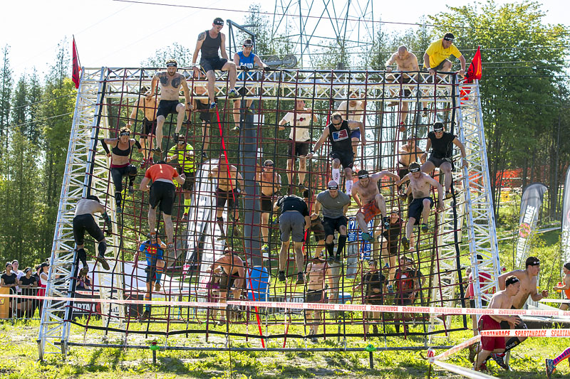 Spartan race participants climbing on an obstacle