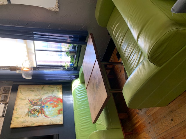 A table by the window with comfy green couches at The Yardbird Restaurant in Bowmanville.