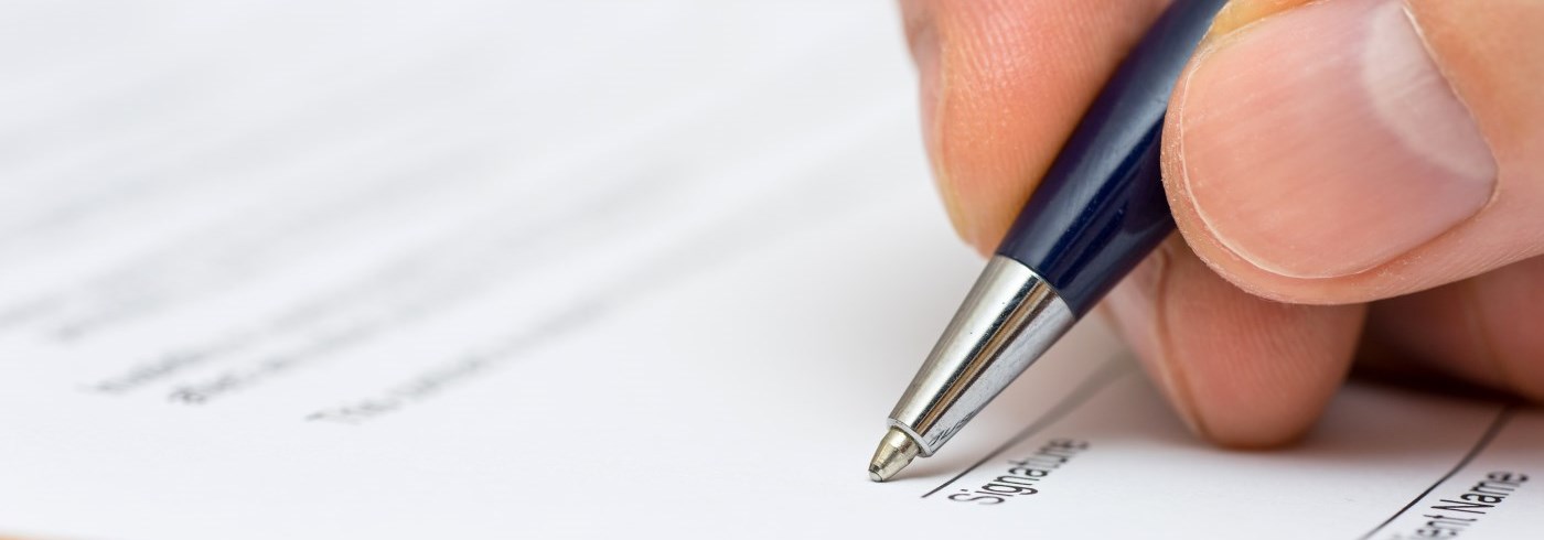 Person using a pen to fill out an application