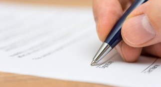 Person using a pen to fill out an application