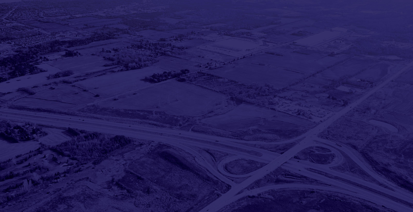 Drone shot of vacant land with nearby highways.