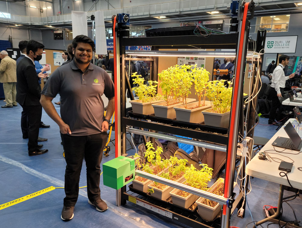 Controls Systems Lead Tushar Patel with Moduleaf's Autonomous Vertical Farm Monitoring Robot Prototype Displayed at Ontario Tech University's Engineering Capstone Exhibition.