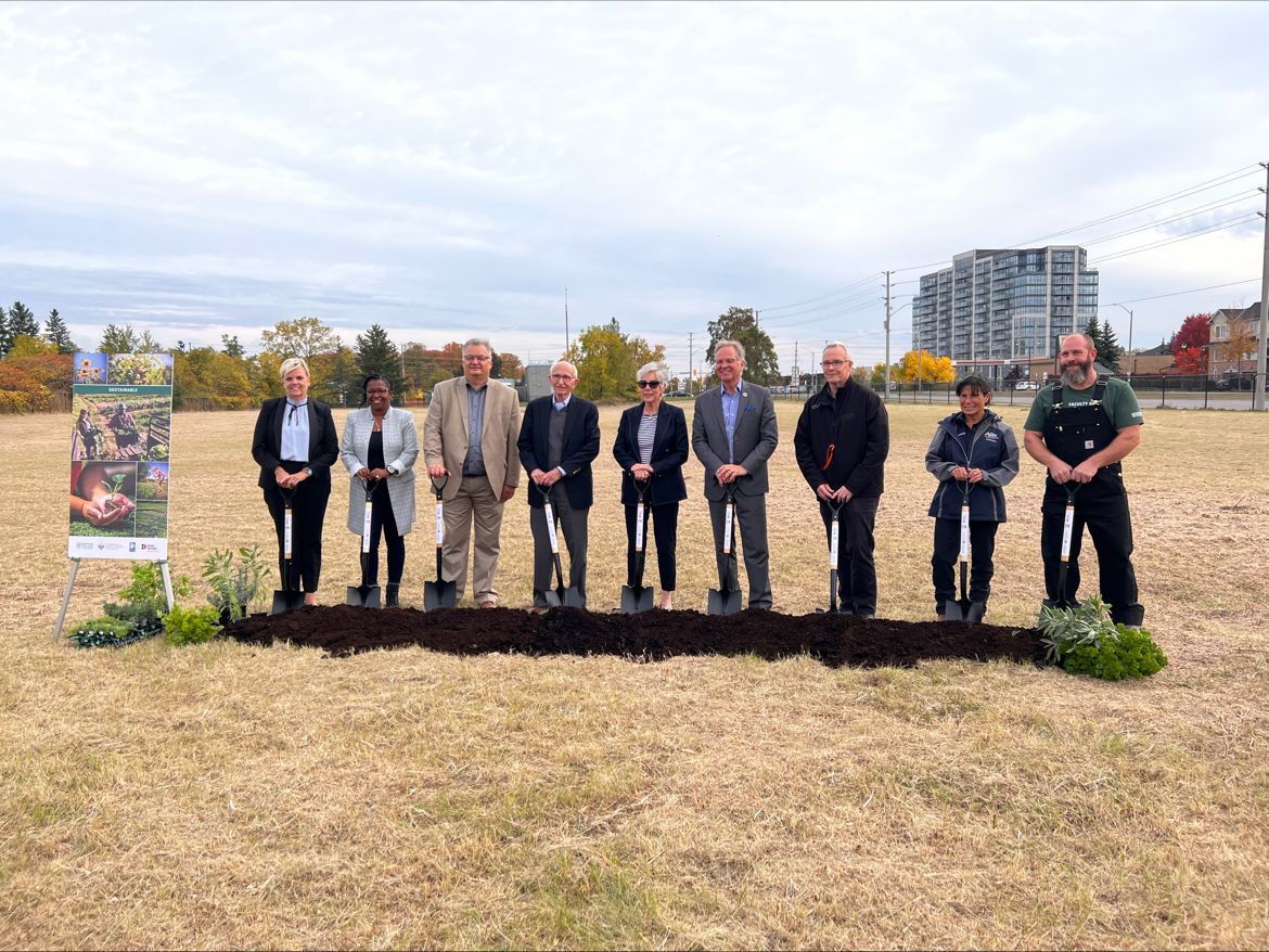 Group of Durham College staff and community partners holding shovels at the future Barrett Centre site.