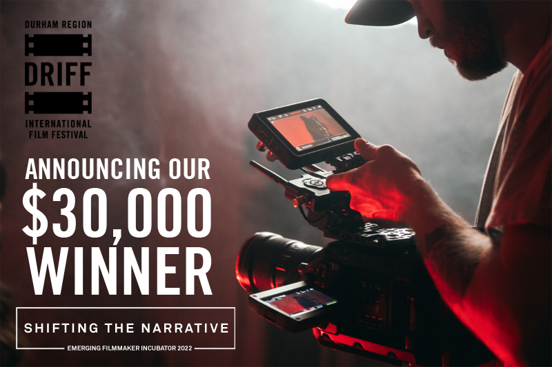 Man holding a camera with text that reads, "Announcing our 30,000 winner".