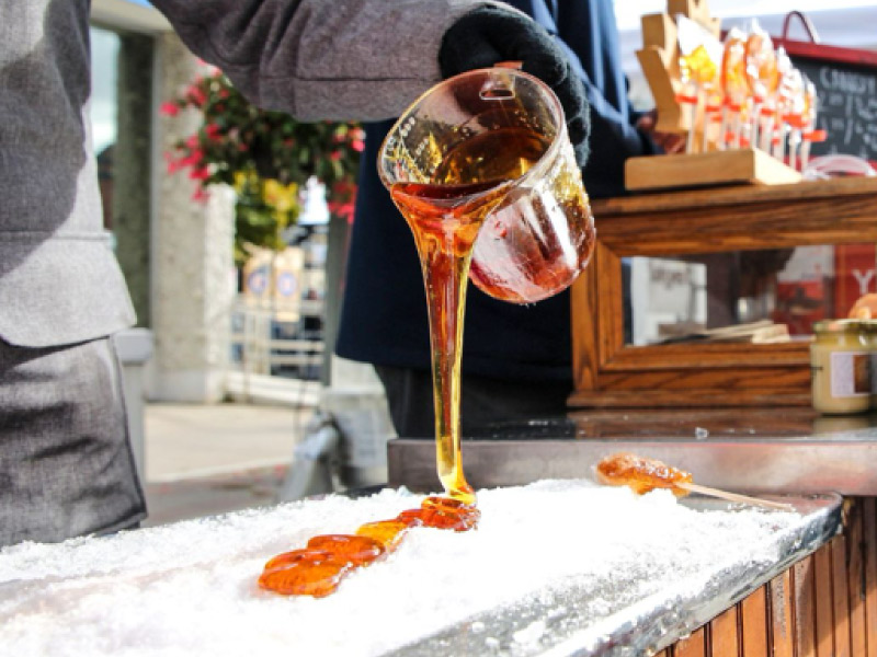Maple syrup poured over snow at a festival.