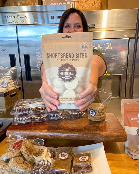 Woman holding a package of shortbread cookies at the Eat My Shortbread bakery.
