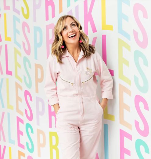 Founder of Sweetapolita in front of a fun colourful backdrop with the word "Sprinkles" repeated.
