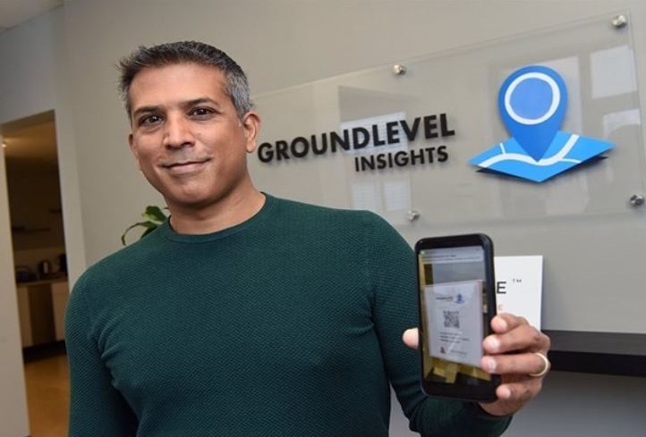 Founder of GroundLevel Insights holding a phone.