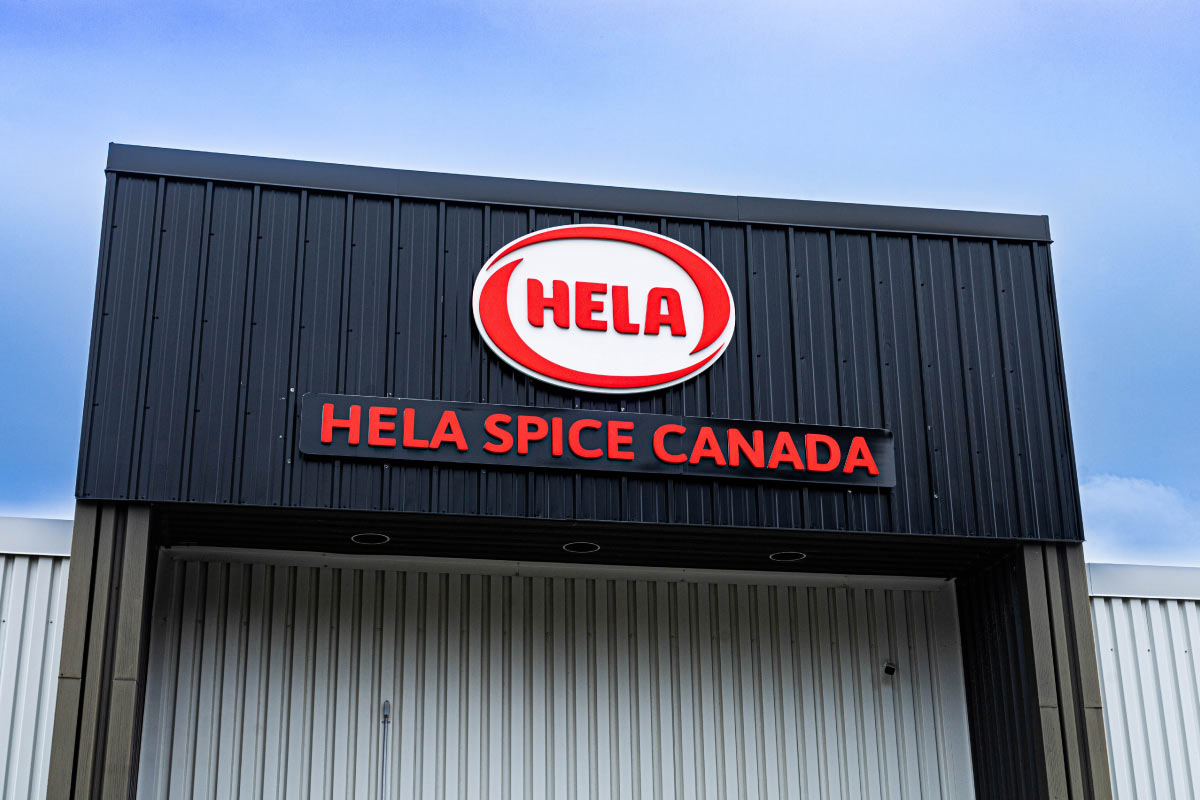 Hela Spice Canada sign on building with a blue sky in the background.