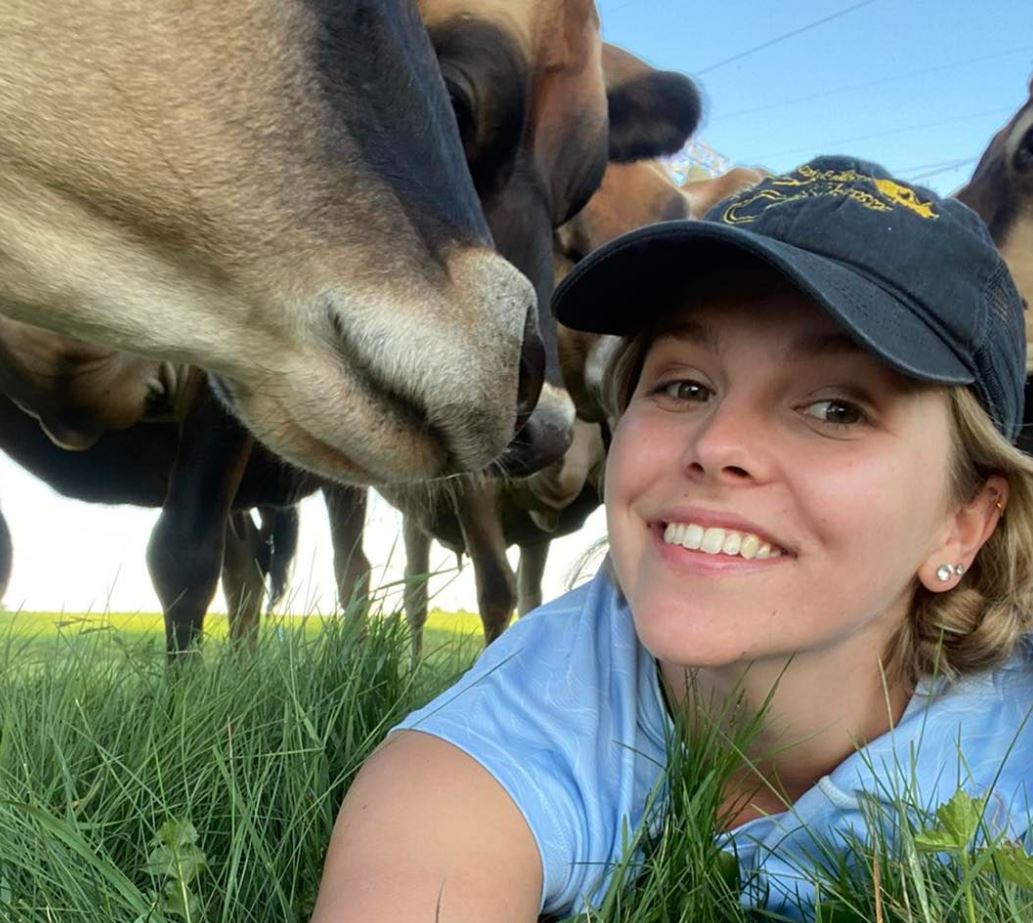 Selfie of Melyssa at Sargent Family Dairy with cows.