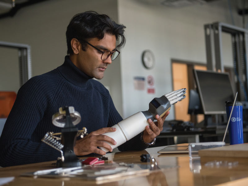 smartARM Founder, Hamayal Choudhry, holding a prototype of a robotic arm.
