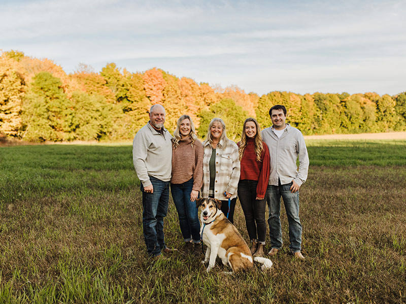 West Port Dairy family shot with large trees in the background.