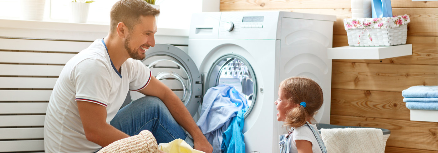 Father and young daughter in the laundry room.