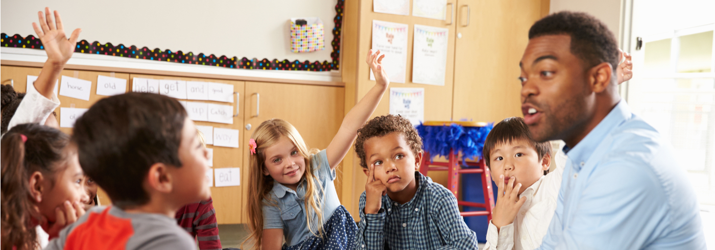 Educator interacting with children in his classroom.