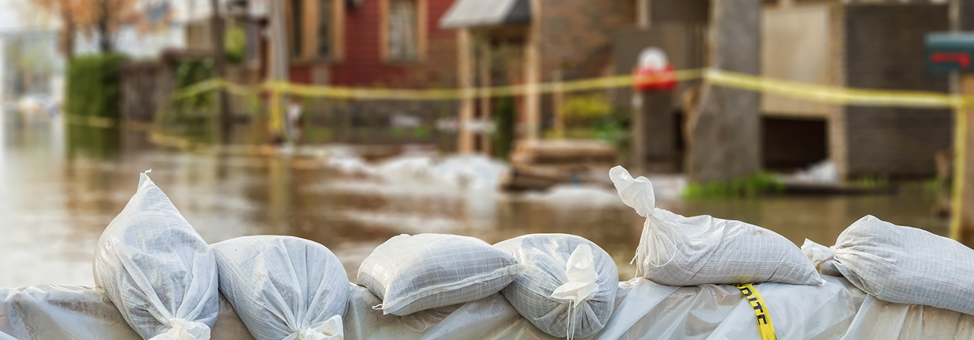 Flooded street lined with sandbags.