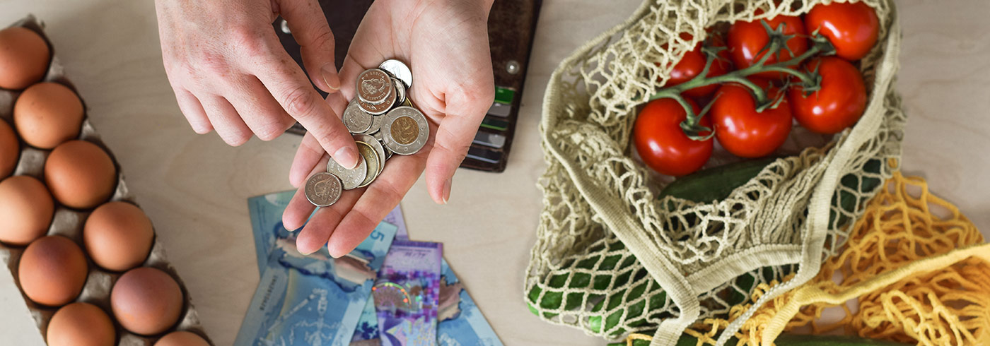 Hands counting money over food on the table