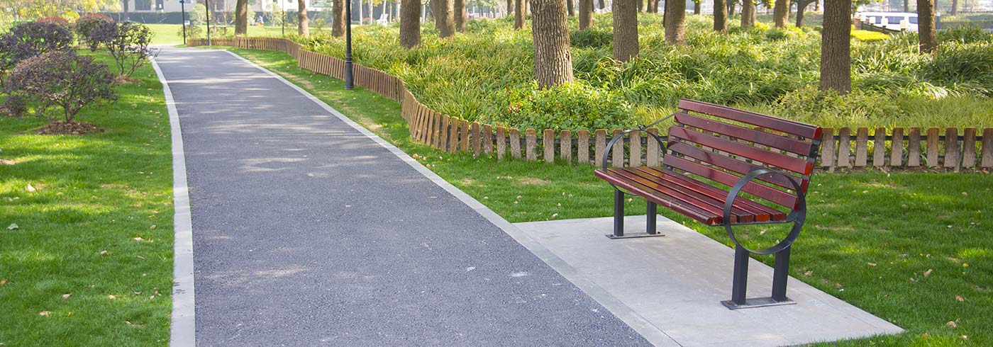 Park with a bench and walking path. Park with a bench and walking path.