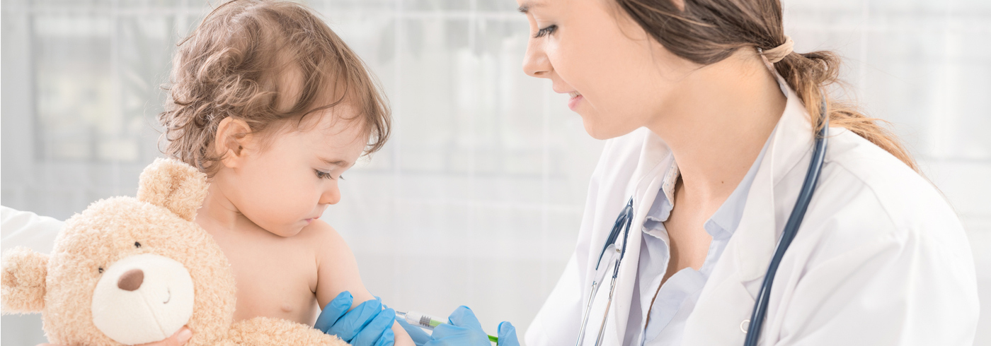 A young child receiving a vaccination from her health care provider.