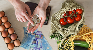Hands counting money over food on the table