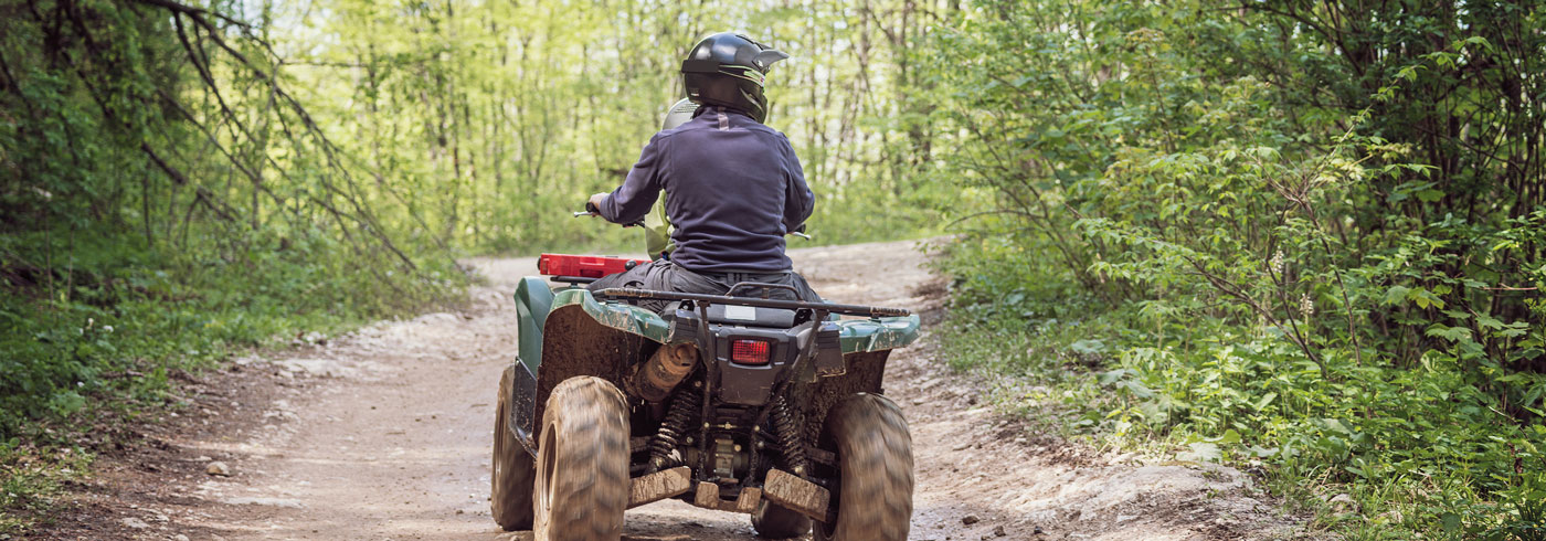People riding an all terrain vehicle on a designated trail.