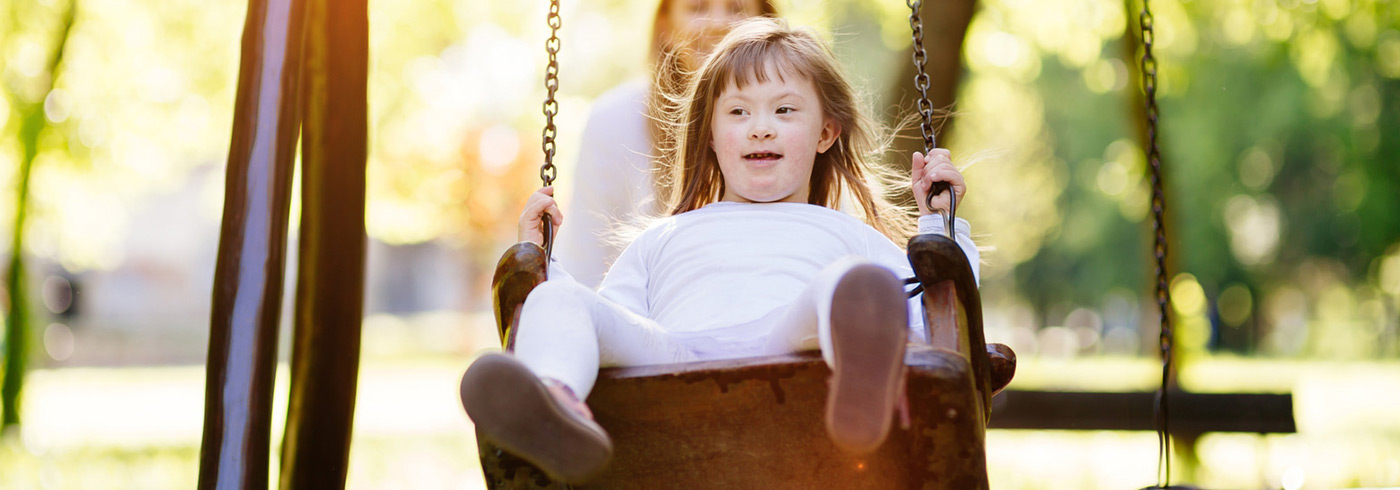 Young girl on playground swing.