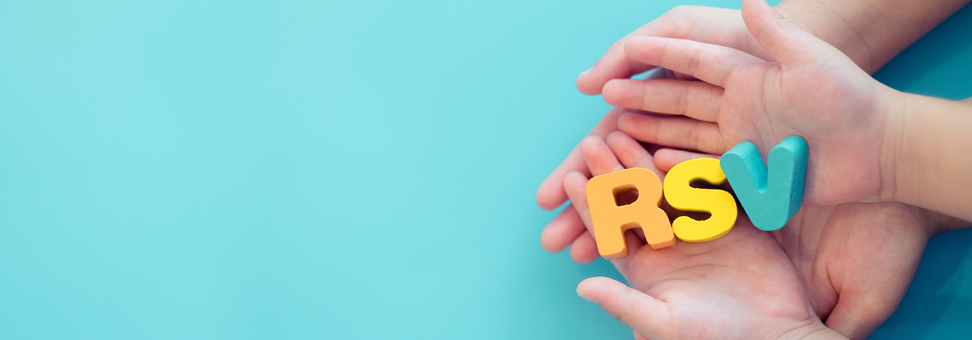 Hands holding blocks with the letters RSV