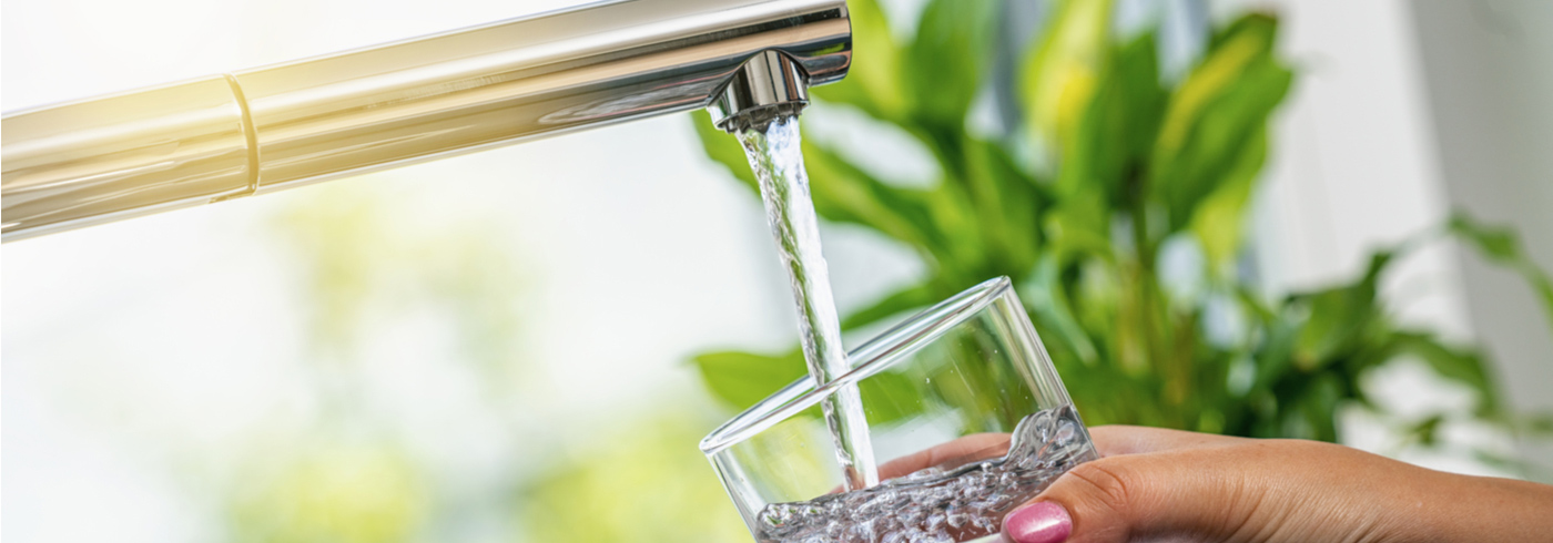 Filling glass with tap water.