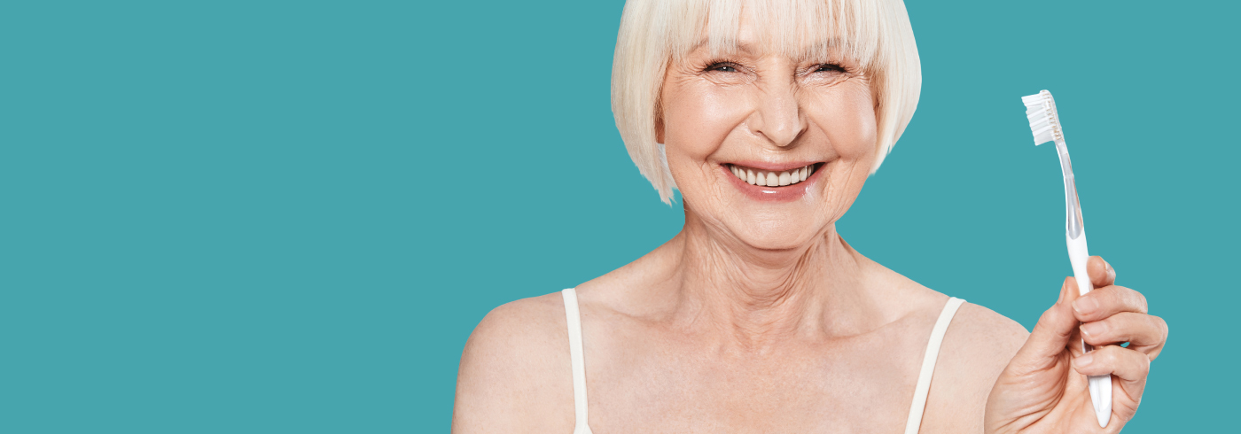 Senior woman holding a toothbrush and smiling.