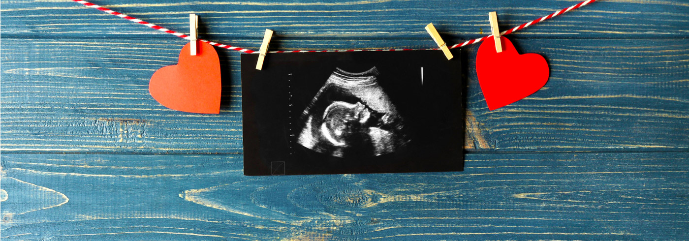 Paper hearts and an ultrasound picture hanging from a decorative string.