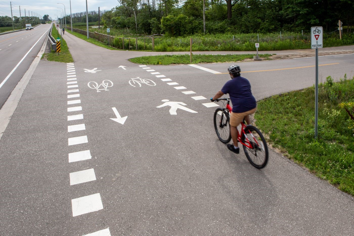 Man cycling through a mixed crossride at an unsignalized crossing.